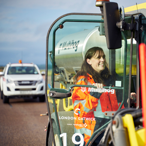 a smiling woman opening the door to an airfield vehicle